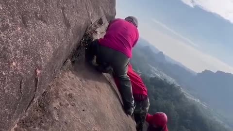 Terrifying moment Chinese hiker nearly falls off a cliff.