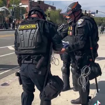 CHP officers fold American flag that was hanging upside down in downtown Los Angeles.