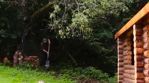 A man builds a house in the forest with his own hands