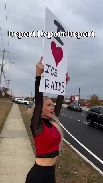 Woman peacefully protests by busy road "I Love ICE Raids"