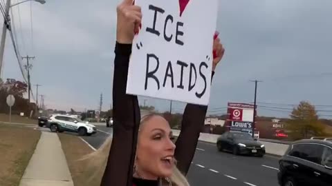 Woman peacefully protests by busy road "I Love ICE Raids"