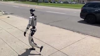 Humanoid robot walking down a Detroit street