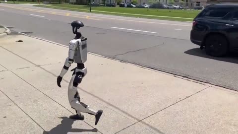 Humanoid robot walking down a Detroit street
