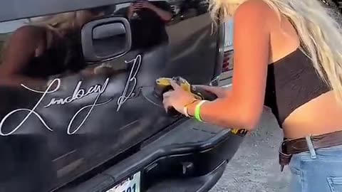 Girl writing on car making logo