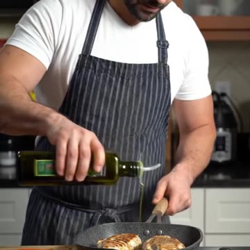 A man grills seasoned chicken breasts
