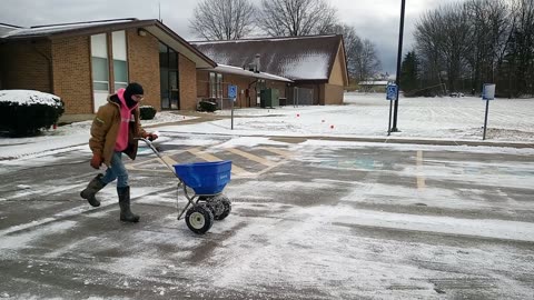 Salt spreading parking lot with a push spreader