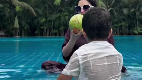 Popular BD actress Porimoni eats a green coconut in the swimming pool.