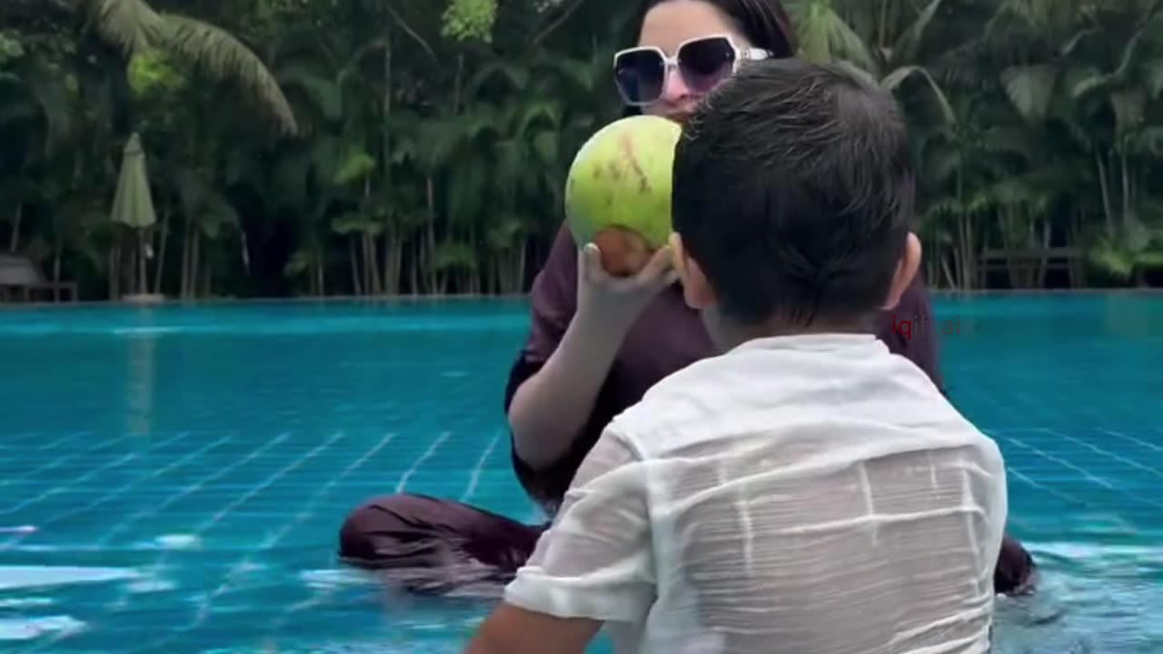 Popular BD actress Porimoni eats a green coconut in the swimming pool.