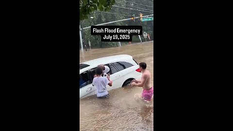 Men and firefighters rescue women from a sinking car after severe storms trigger major flooding