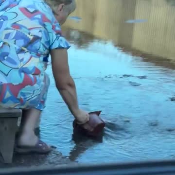 Old Woman Drinking from Puddles in Russian Occupied Makiivka