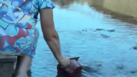 Old Woman Drinking from Puddles in Russian Occupied Makiivka