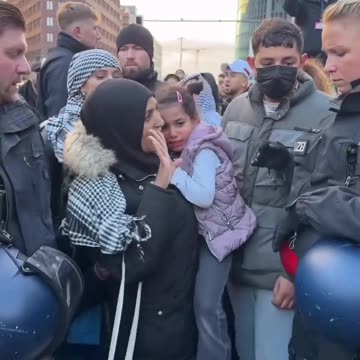 German police detain a woman and her crying children