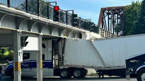 Transport truck full of alcohol gets stuck under Fredericton overpass