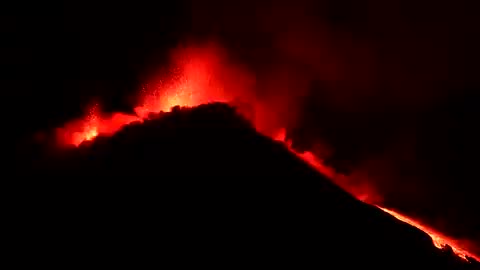 Mount Etna lit up the night as gas clouds and lava cascaded from Europe's most active volcano.