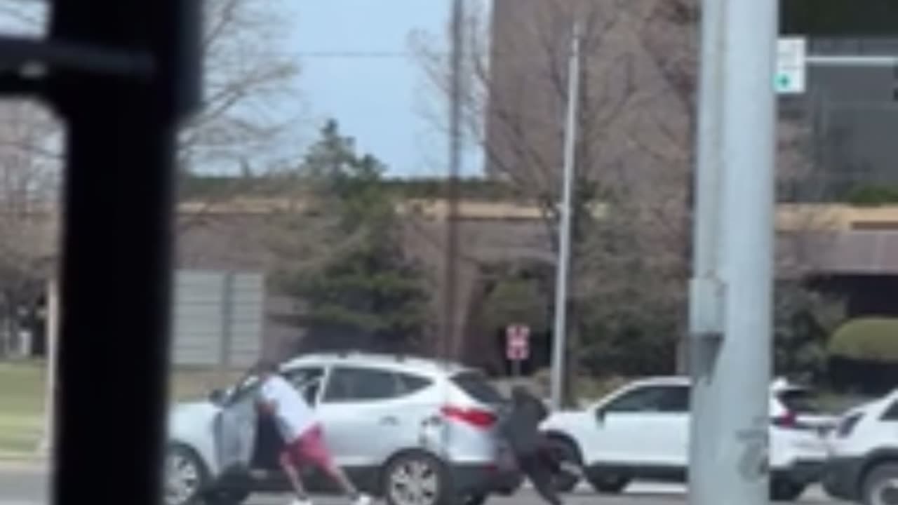 Woman Stumbles While Helping Move Stalled Vehicle at Traffic Light