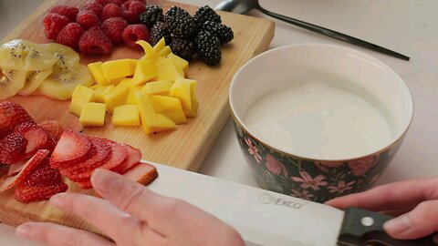 Preparing a bowl with yogurt and fruit