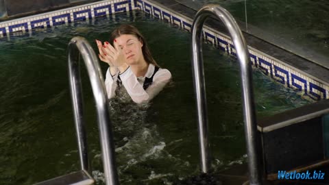 Wetlook girl dressed in office attire, takes a swim in the pool