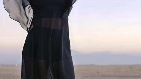Woman posing for the camera in the middle of a desert