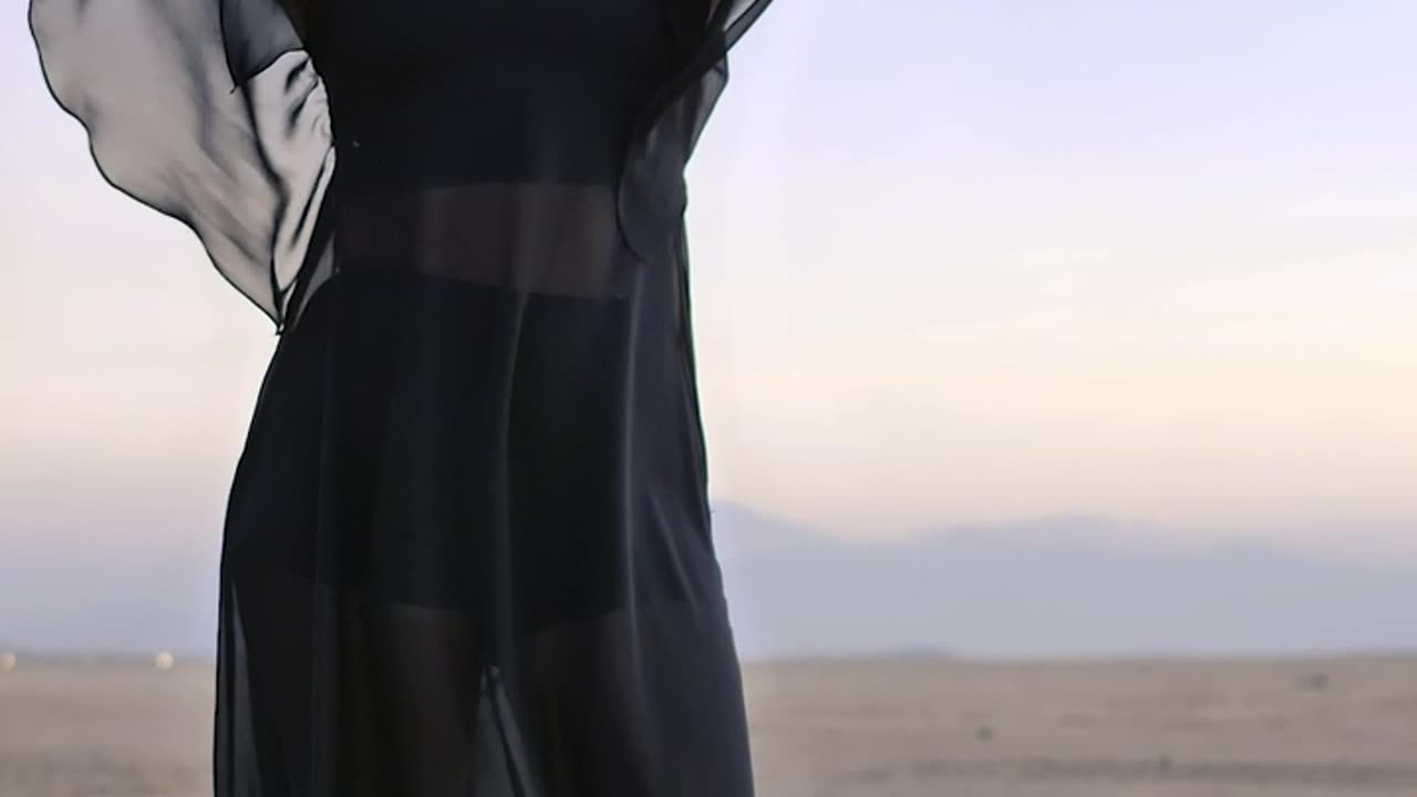 Woman posing for the camera in the middle of a desert