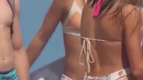 Young beautiful girls in bikini undress on the beach