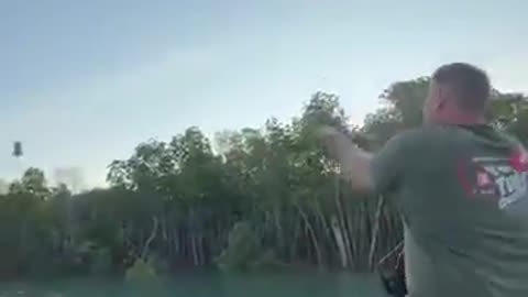Man throws fish and an eagle catches it in mid-air, what a shot