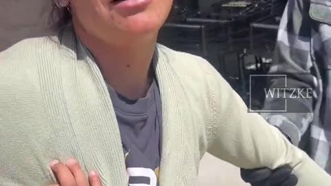 Woman with child accused of stealing being detained by security at grocery store