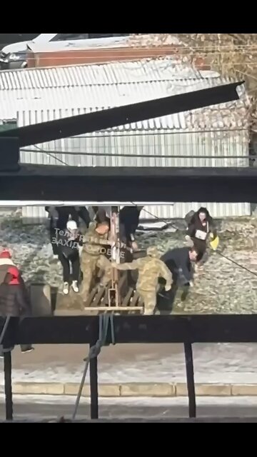 A girl holds a child in her arms. The father is taken away to his death. A military commissar