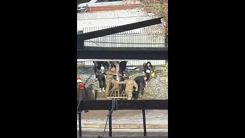 A girl holds a child in her arms. The father is taken away to his death. A military commissar