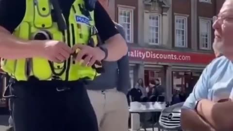 A British officer warns an elderly man that saying “Speak English” could be a hate crime.