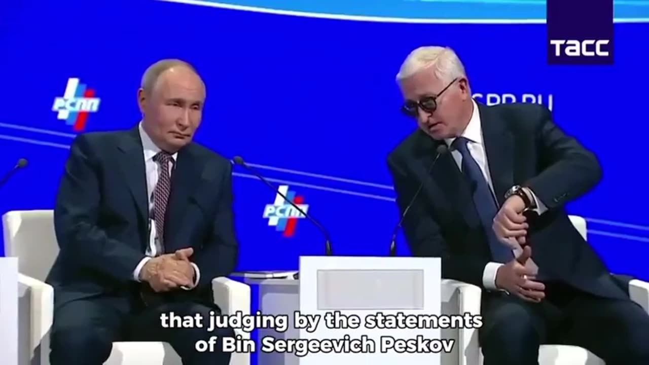 The crowd laughs as Vladimir Putin shrugs for having made Donald Trump wait for their meeting