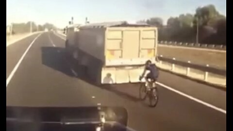 Aussiecams - Cyclist slipstreams a Truck and dog on the freeway 🤦🏼‍♂️ in the right lane!