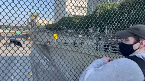 Los Angeles — A masked insurrectionist holds a Mexican flag and a prop severed President Trump head