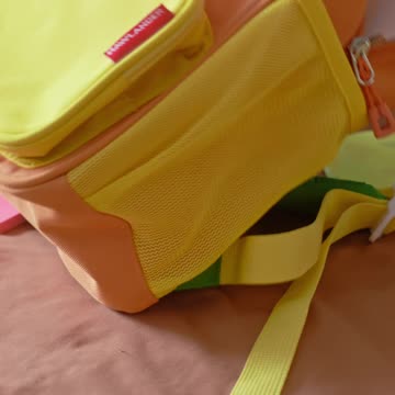 Close-up of colorful school supplies spread out on a girl’s bed.