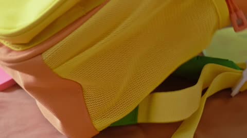 Close-up of colorful school supplies spread out on a girl’s bed.