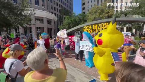 Protesters dressed in inflatable costumes dance for the crowd at the No Kings rally
