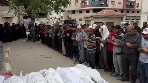 Palestinians pray over the bodies of the family of journalist Osama Al-Arbeed