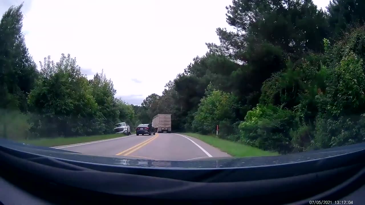 Driver Attempts Passing Truck on Blind Corner