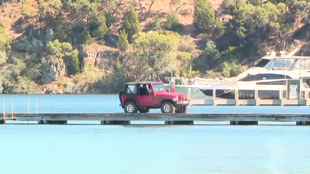 Car plunges off jetty into water in Australian police standoff