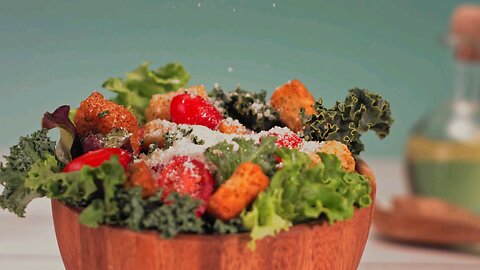 Parmesan cheese sprinkled in slow motion over a green delicious salad