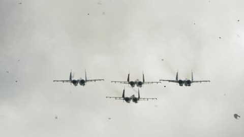 Four fighter jets flying through an overcast