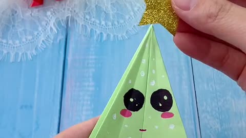 Cute Handmade Origami Christmas Trees on Blue Wooden Background