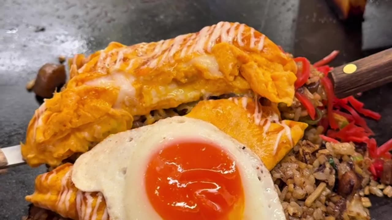 Cooking fried rice with omelette as a topping