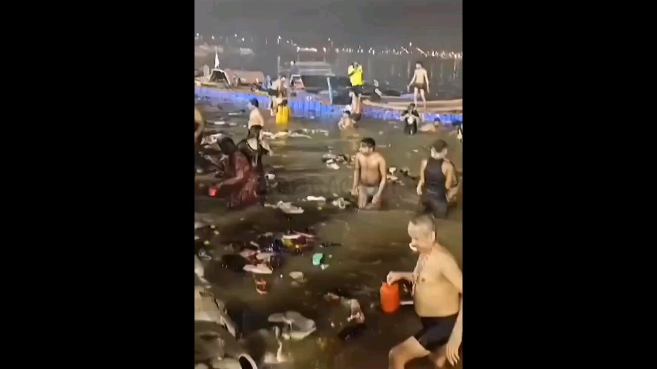 The people of India swimming in a river with trash floating around in it