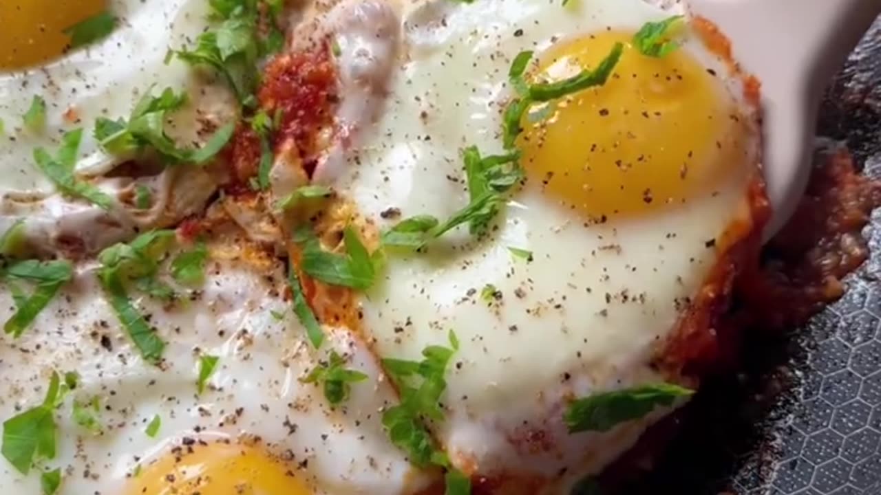 Making a breakfast meal, eggs cooked with tomato paste