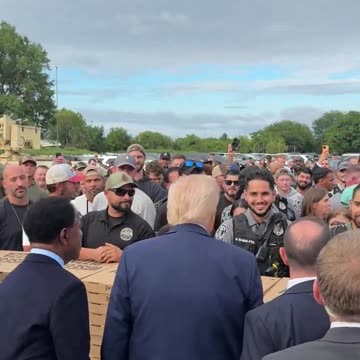 President Trump shakes hands with law enforcement over boxes of Pizza