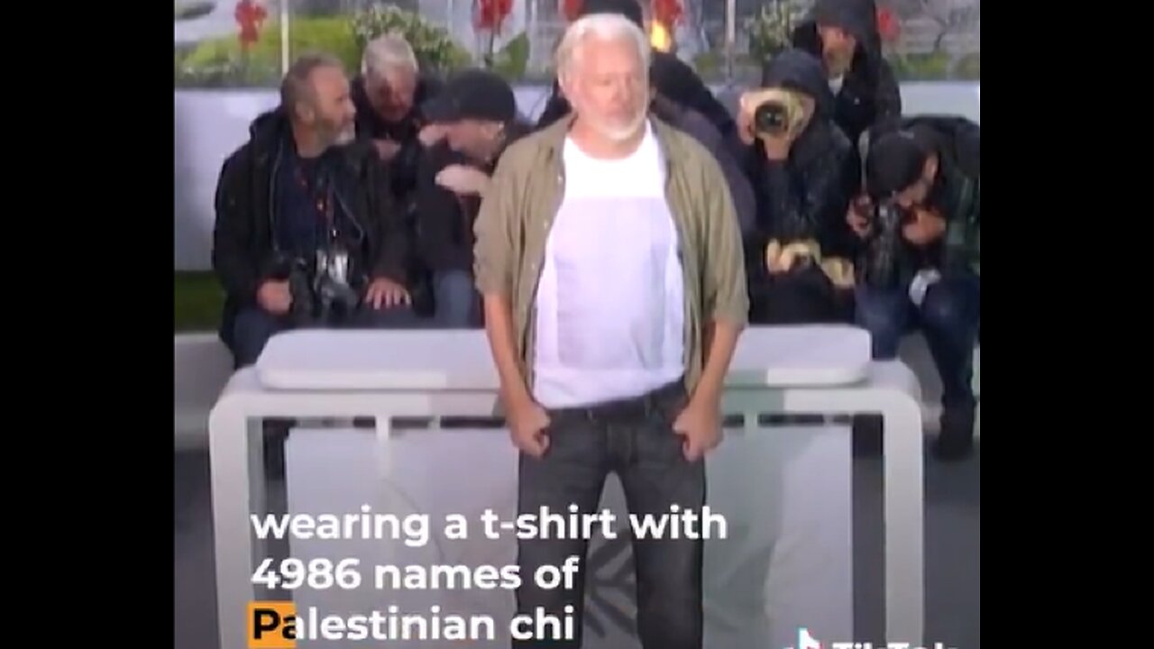 Julian Assange at Cannes Film Festival, displaying the names of 4,986 Palestinian children murdered in Gaza by Israel
