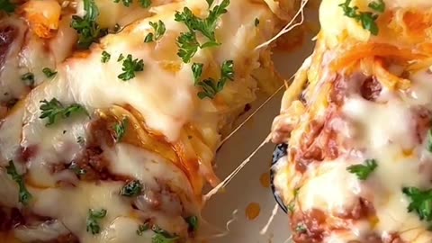 Potato and carrot pancake with beef and cheese as a filling and cheese topping on it.