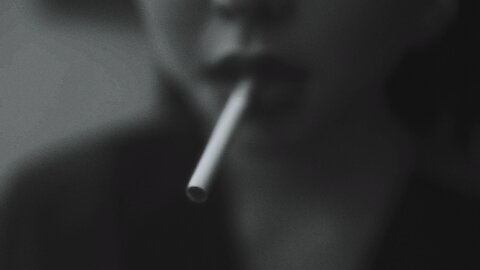 Close up View of a Woman Lighting a Cigarette with a Match