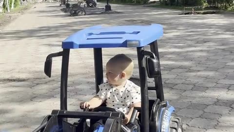 Girl Falls Asleep at the Wheel of a Toy Tractor