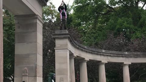 PROTESTER FREE CLIMBS LARGE STRUCTURE